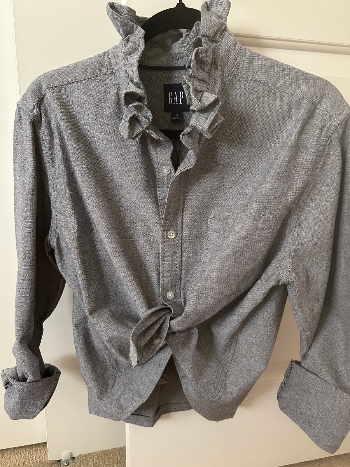 Millie is a light gray oxford shirt witha ruffled collar