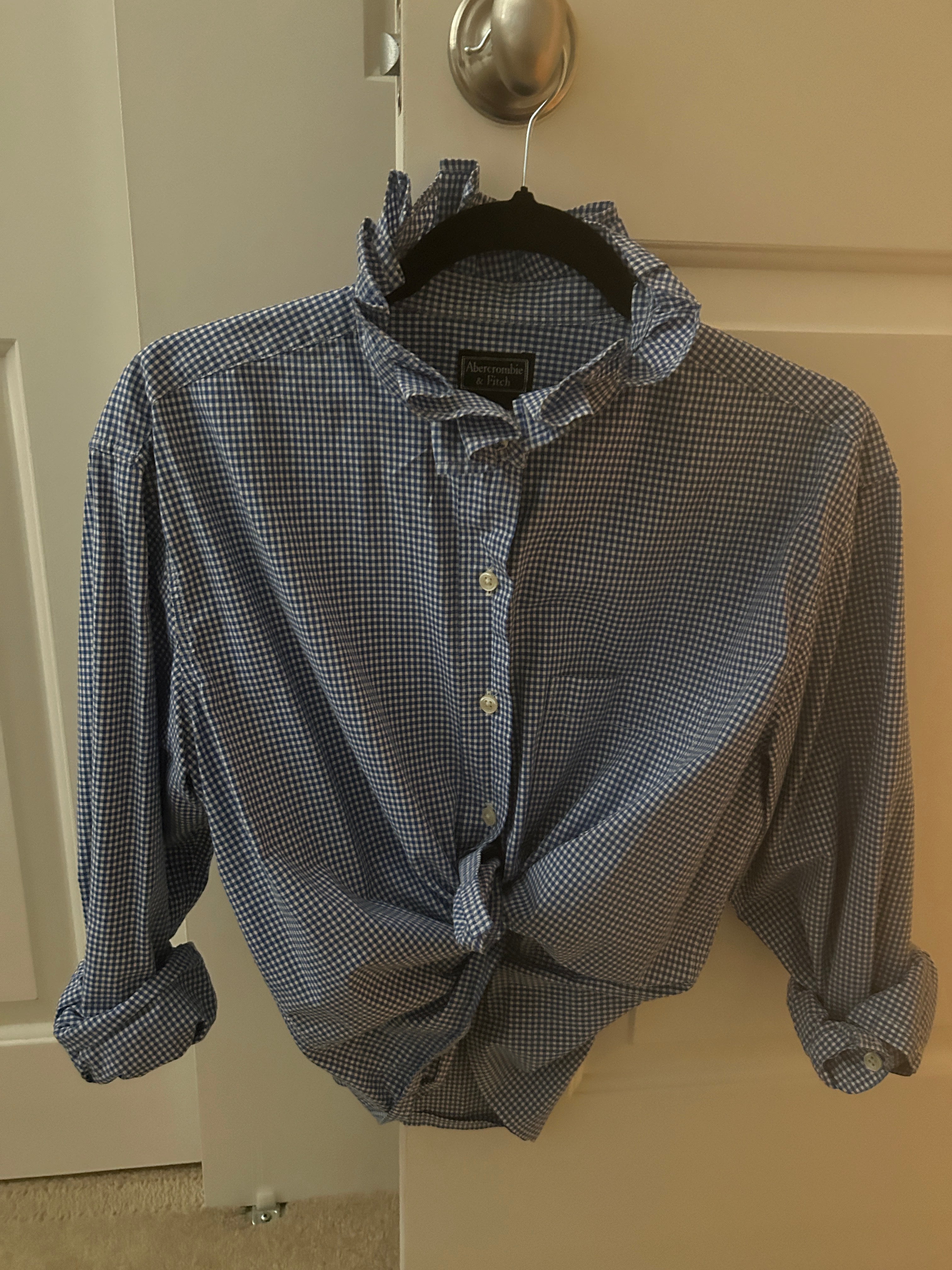 Blue micro-gingham ruffled collar top on hanger with front knot detail